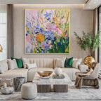 Modern colorful floral canvas painting with gold frame displayed above a sofa in an elegant living room