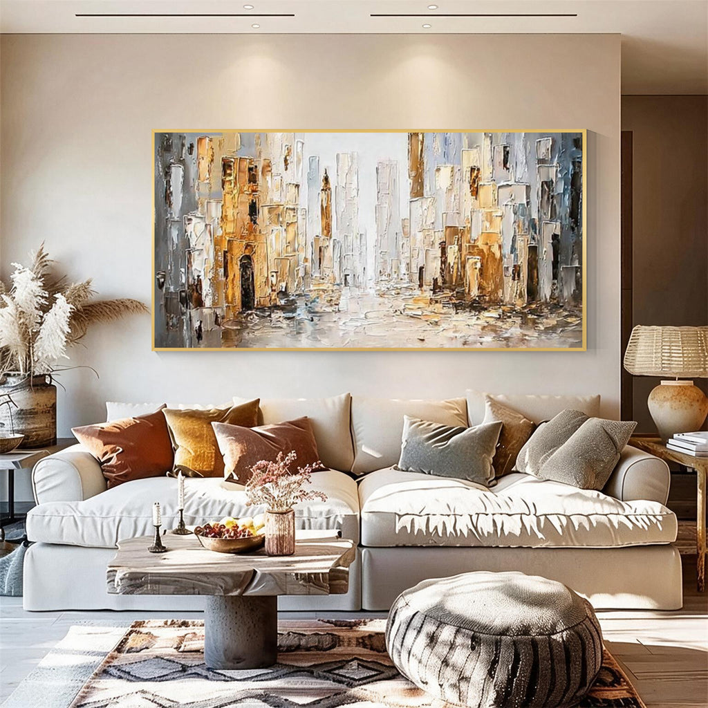 Abstract cityscape wall art with gold frame displayed above a sofa in a modern living room