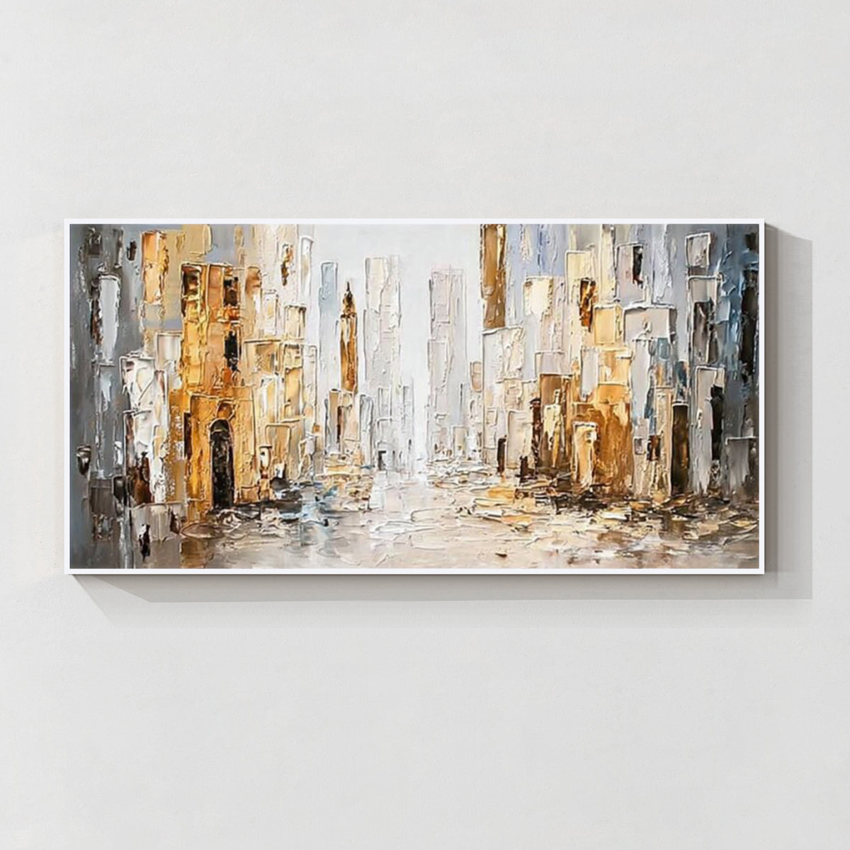 Abstract cityscape wall art with white frame featuring textured buildings in white, gray and gold