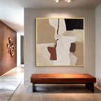 Beige abstract wall art displayed above a bench in a modern entryway with minimalist interior decor
