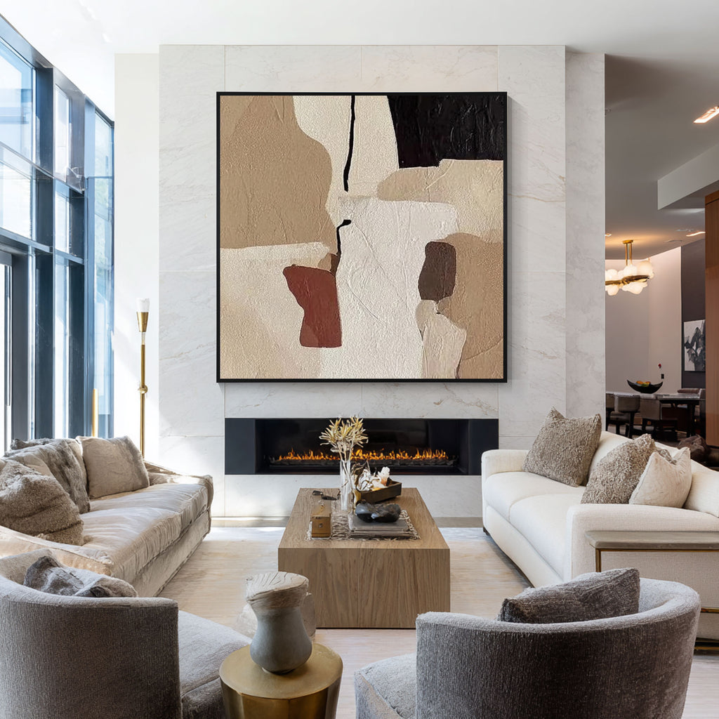 Beige abstract wall art above a fireplace in a modern luxury living room with neutral interior decor