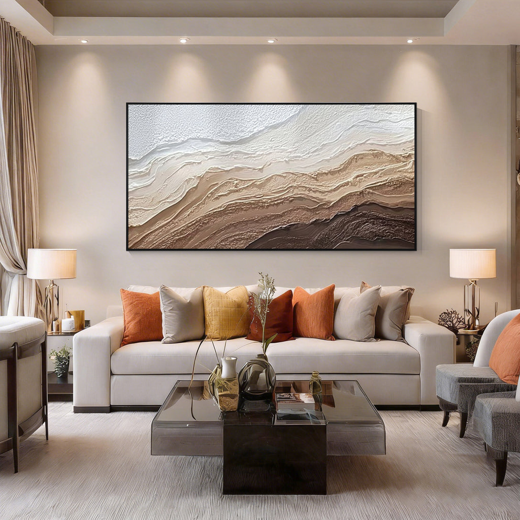 Modern abstract textured wall art with black frame displayed above a sofa in a minimalist living room, neutral brown and beige canvas artwork for home decor
