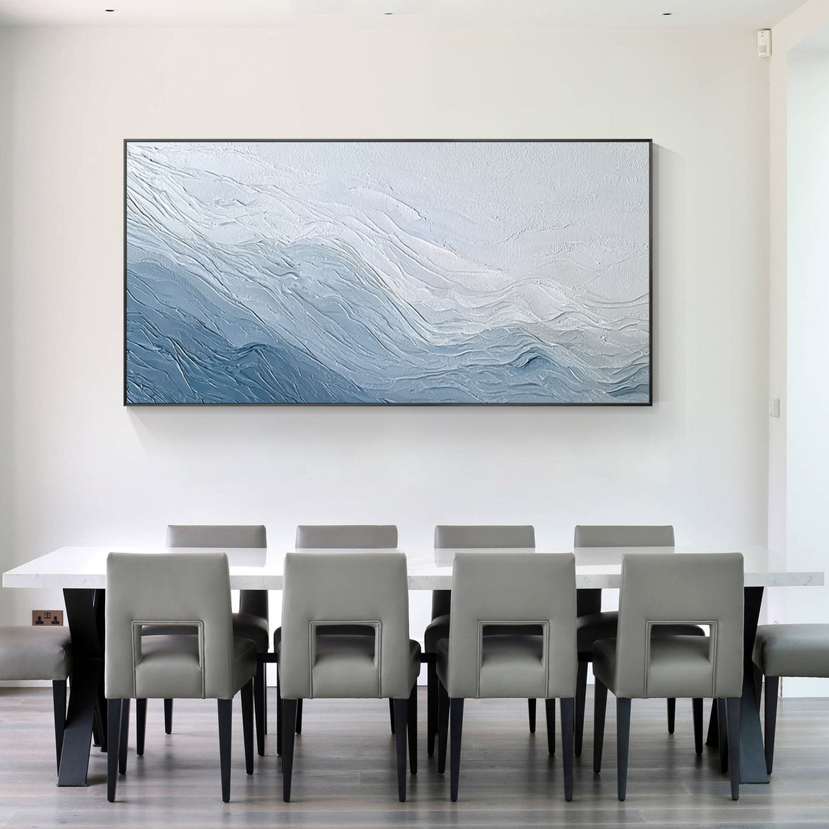 Blue and white textured abstract wall art painting displayed in a modern dining room above a dining table