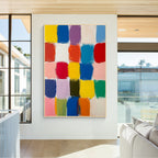 Colorful block abstract wall art with gold frame displayed in a modern living room, featuring vibrant color squares, textured brush strokes and contemporary home decor style