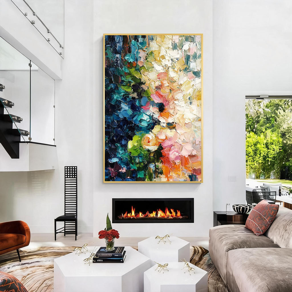 Colorful blue green pink and orange textured abstract wall art with gold frame displayed above a fireplace in a modern living room, featuring layered brush strokes and contemporary home decor