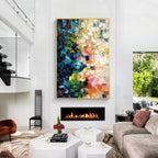 Colorful blue green pink and orange textured abstract wall art with gold frame displayed above a fireplace in a modern living room, featuring layered brush strokes and contemporary home decor