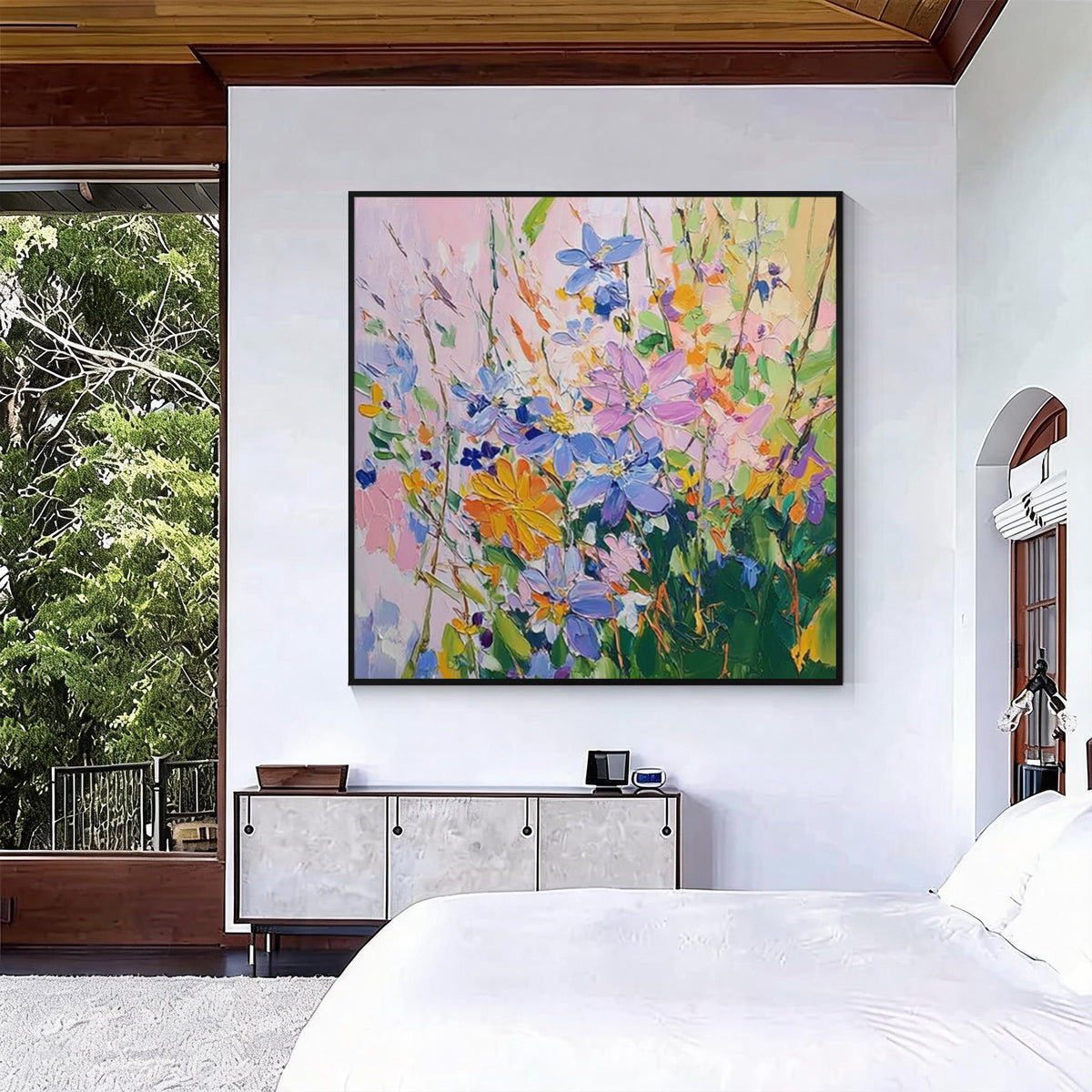 Colorful floral abstract painting with black frame displayed in a modern bedroom interior