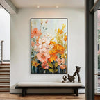 Colorful floral wall art with pink, orange and yellow flowers in a black frame above an entryway bench in a modern home