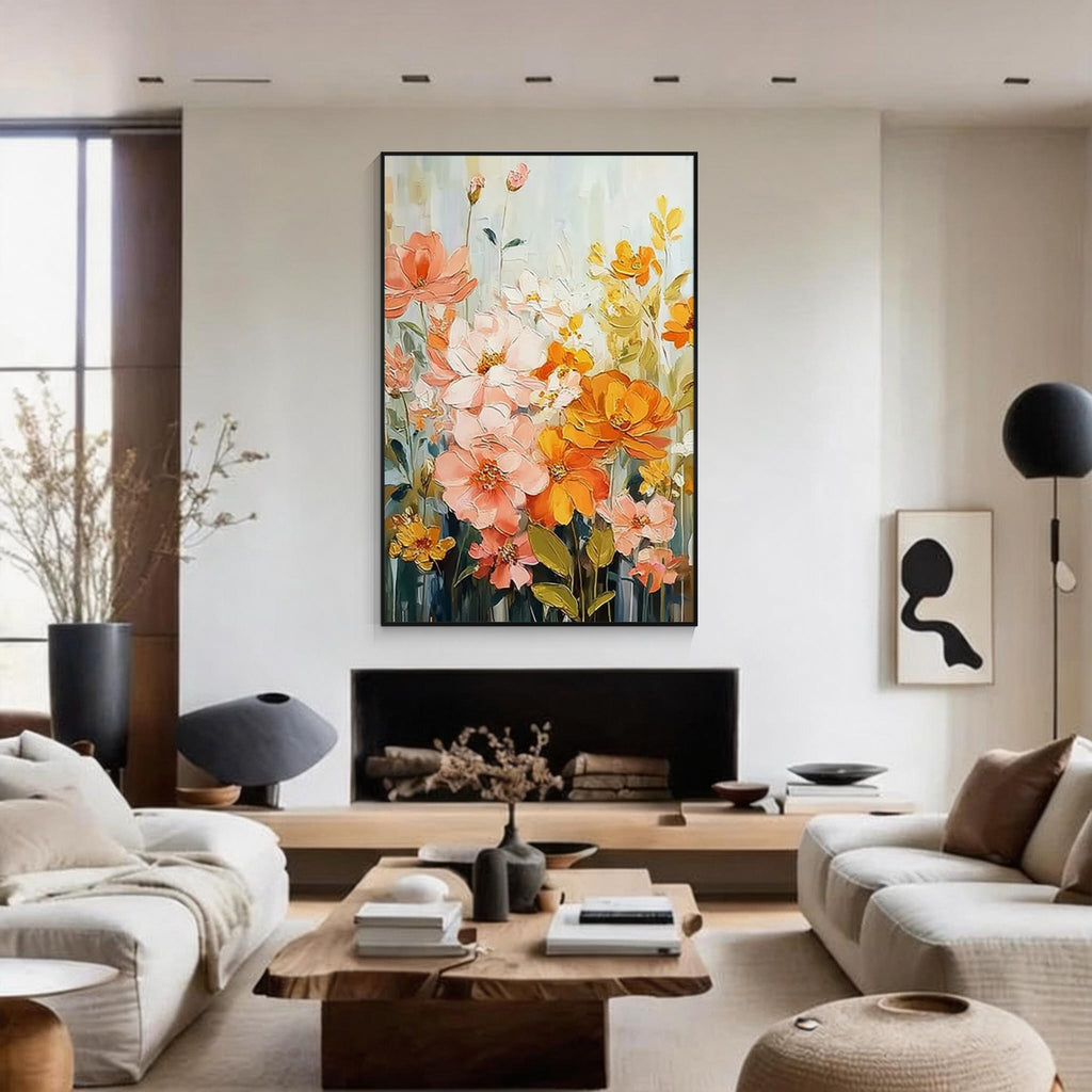 Colorful floral wall art featuring peach pink and golden yellow flowers in a black frame, displayed above a fireplace in a modern neutral living room.