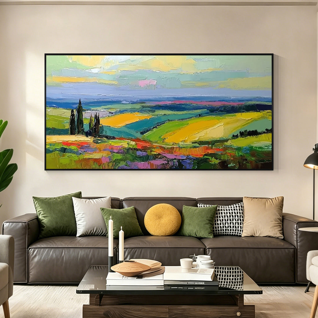 Colorful landscape wall art with black frame displayed above a sofa in a modern living room