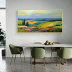 Colorful landscape wall art with gold frame displayed above a dining table in a modern dining room