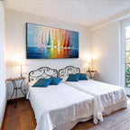 Colorful sailboat wall art with black frame displayed above the bed in a modern bedroom, featuring vibrant sailboats and textured blue water