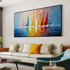 Colorful sailboat wall art with black frame displayed above a sofa in a modern living room, featuring vibrant sailboats and textured blue water