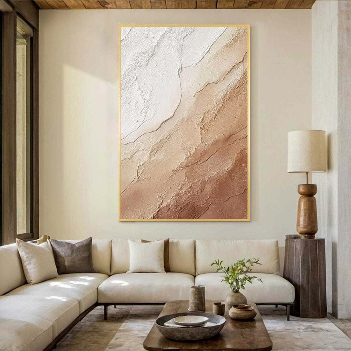 Cream beige textured abstract wall art with gold frame, minimalist plaster style painting displayed in a modern living room