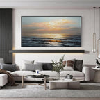 Golden horizon ocean wall art with black frame displayed above a sofa in a modern living room