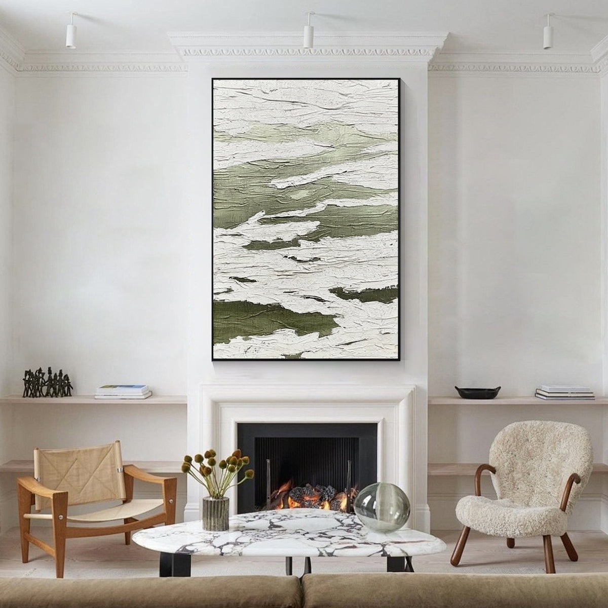 Green and white textured abstract wall art with black frame displayed above a fireplace in a modern living room, featuring layered organic patterns and minimalist interior decor