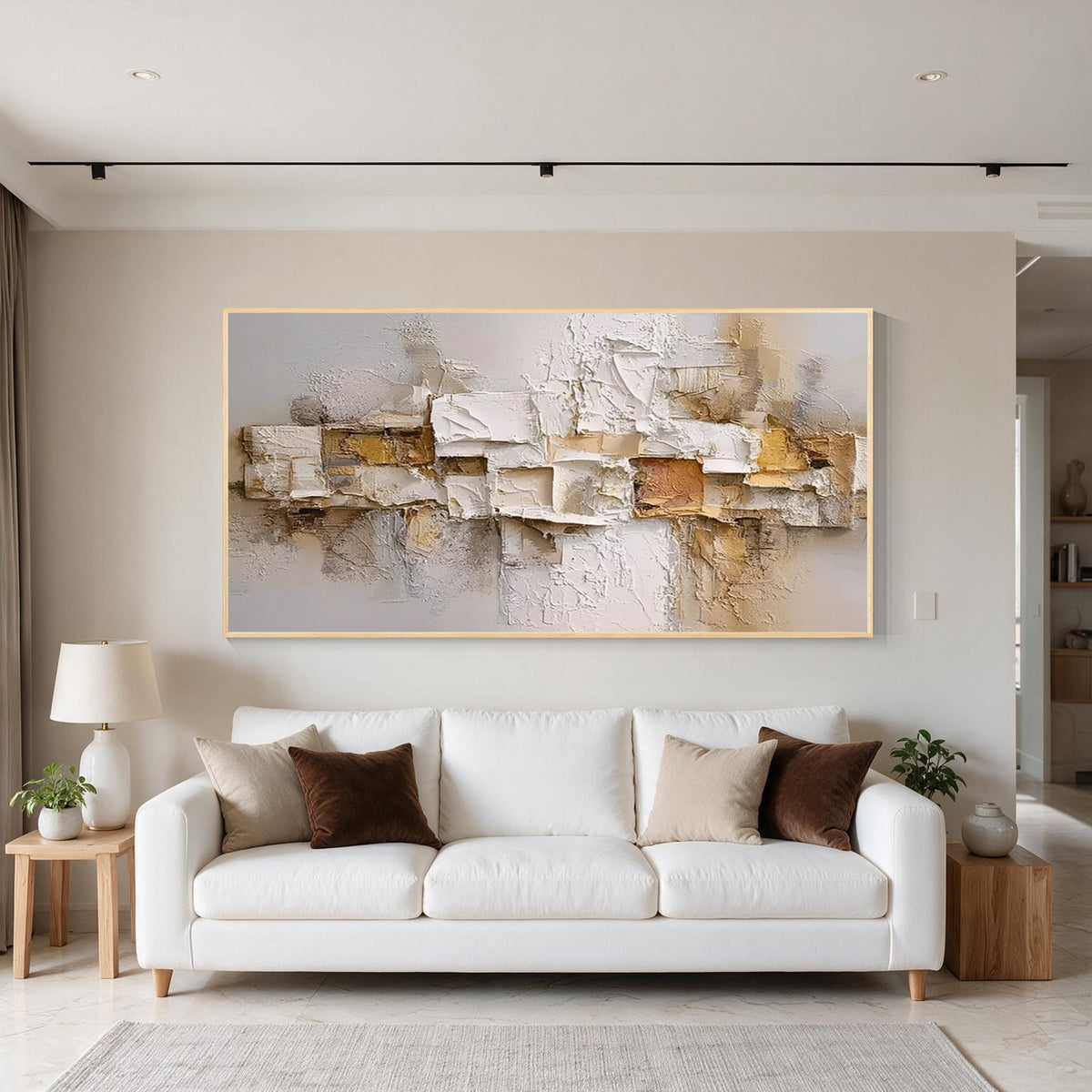 Layered relief textured abstract wall art with gold frame above a white sofa in a modern living room