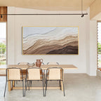 Modern abstract textured wall art with light wood frame displayed in a minimalist dining room, neutral beige and brown canvas artwork for home decor