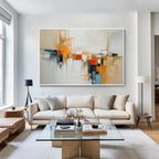 Neutral orange geometric abstract wall art with white frame displayed in a modern living room, featuring textured painting and contemporary home decor