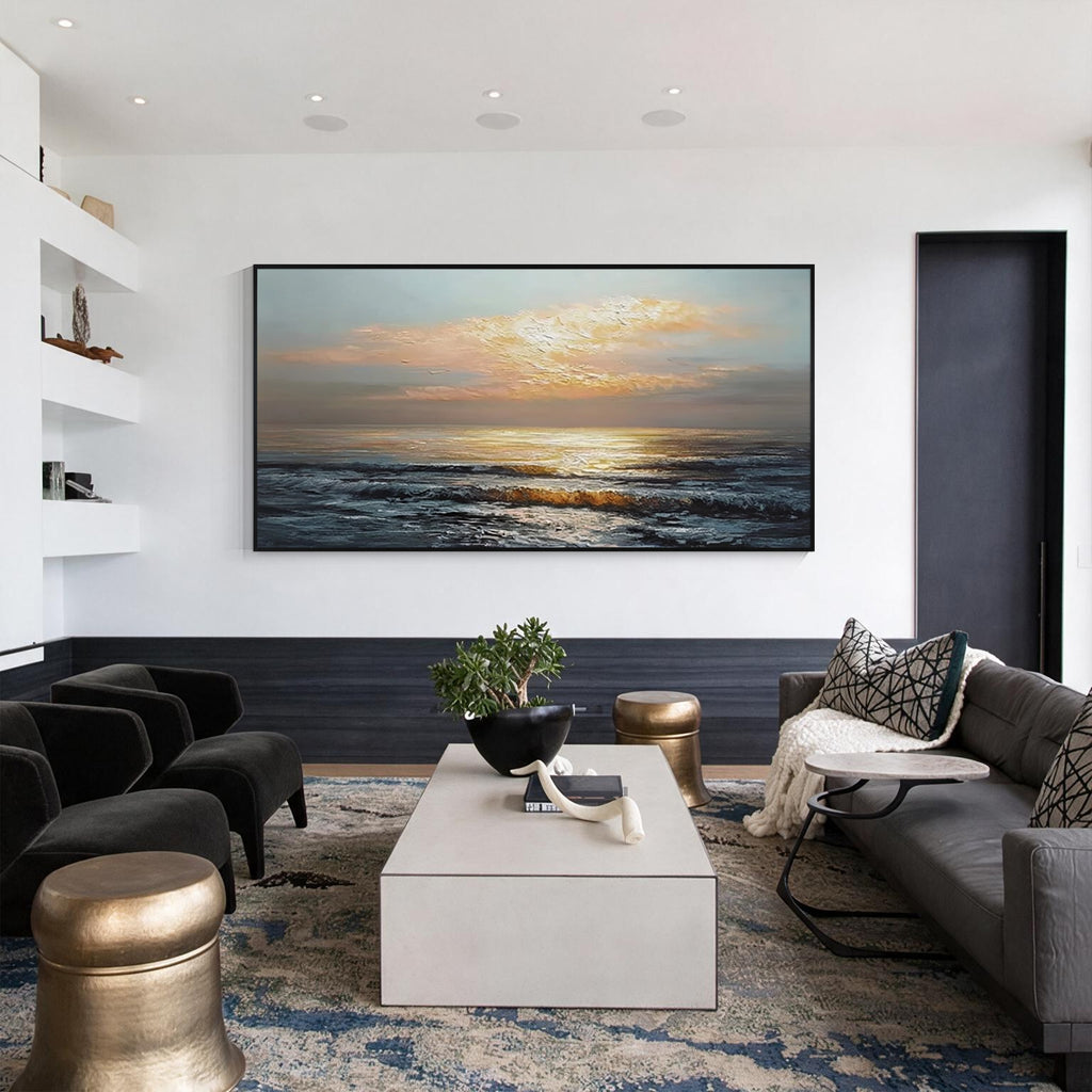 Sunlit ocean wall art with black frame displayed above a sofa in a modern living room