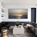 Sunlit ocean wall art with black frame displayed above a sofa in a modern living room